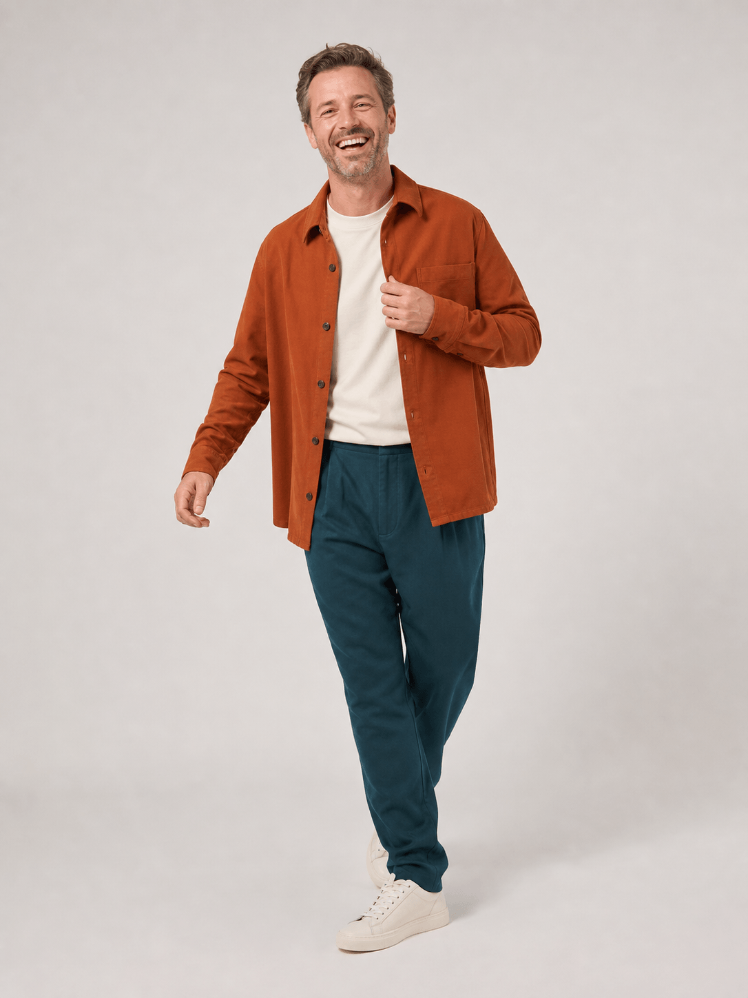 Lachende medewerker in een dynamische looppose in de fotostudio